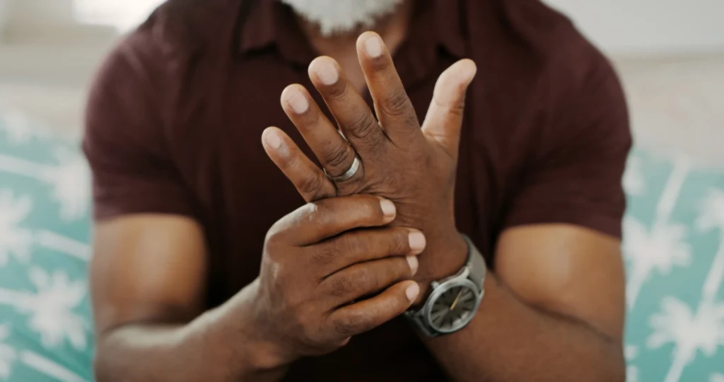 A man holding his hand checking for symptoms